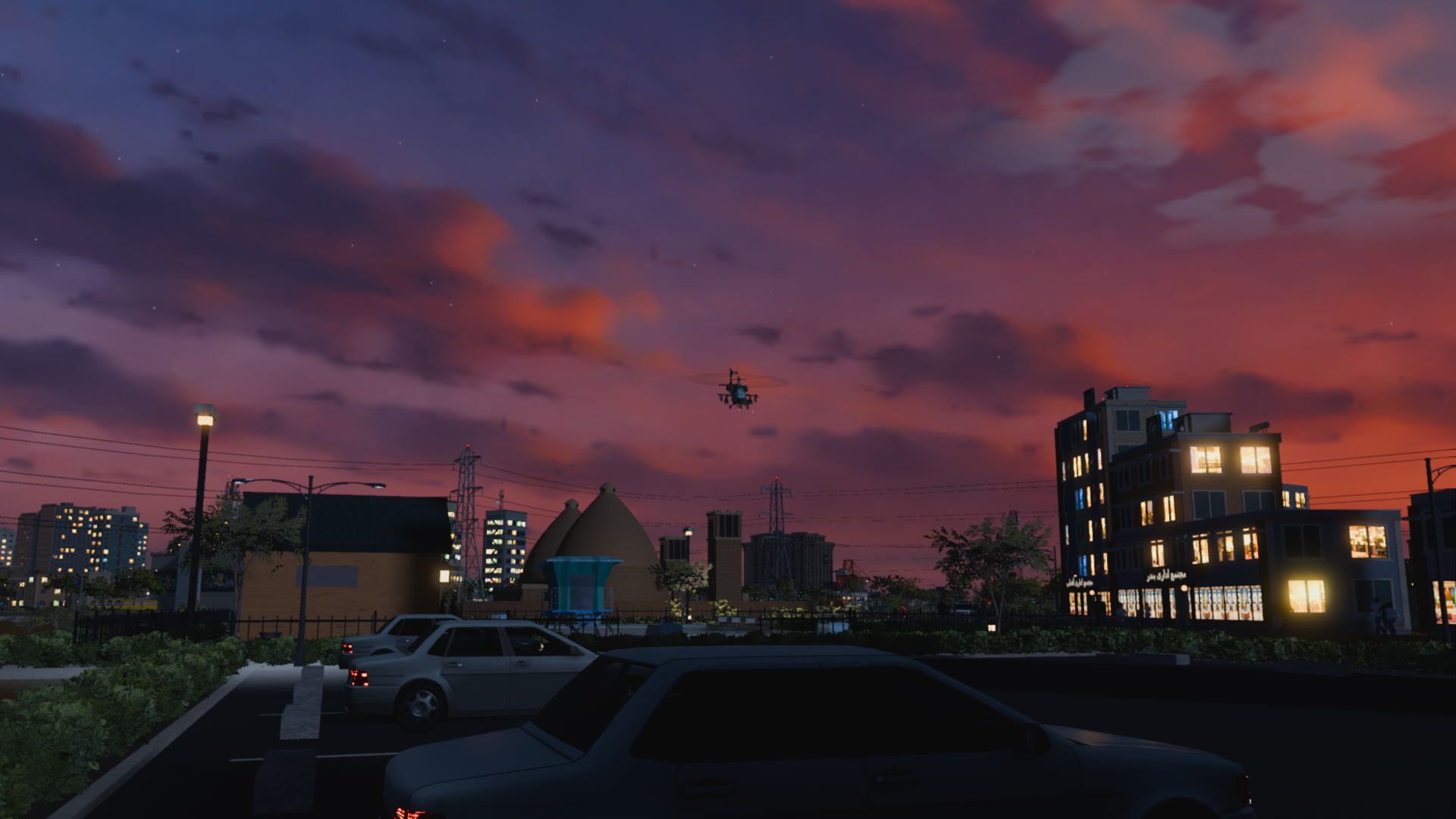 A coastal town at dusk, lit windows and parked cars, the gunship overhead