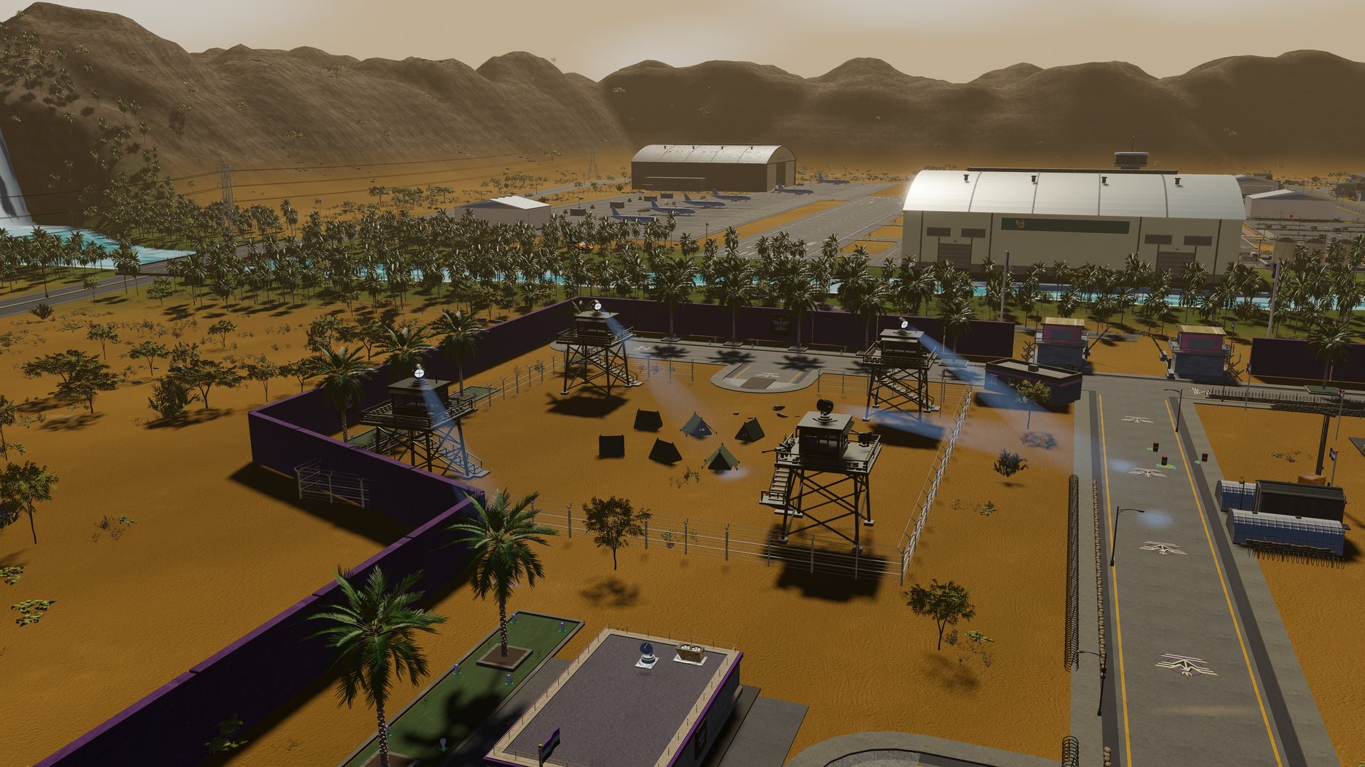 The POW pen: tents inside the wire beside the hangars, watchtowers on the corners